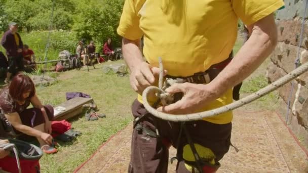 Kryvyi Rih, Ukraina - 05.23.2021 Bergsklättrare som knyter en knut för sele, gamla klättrare ProRes 422, bmpcc4k — Stockvideo