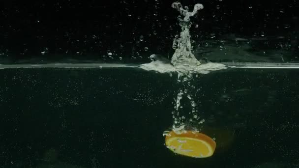 Naranja se sumerge en el agua, cámara lenta, prores 422, bmpcc4k — Vídeos de Stock