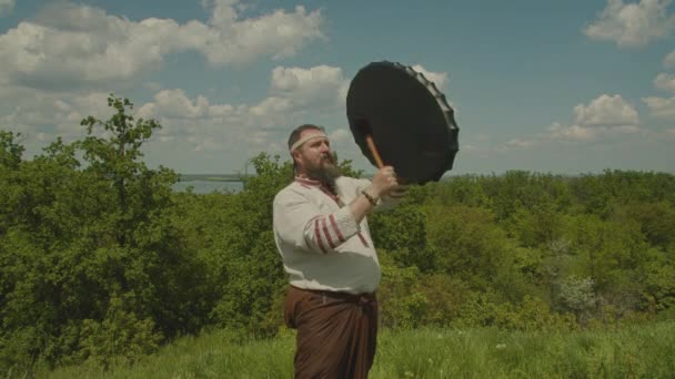 En schuman spelar schamanisk trumma, försöker få det att regna, dyrkar de gamla gudarna och naturen. innebörden av shamanen i naturen, prores 422, bmpcc4k — Stockvideo