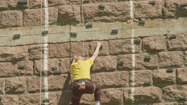 Kryvyi Rih, Oekraïne - 05.23.2021 een rotsklimmer beklimt een stenen standaard, een zuil van een oude brug, een oude klimmers hockey ProRes 422, bmpcc4k — Stockvideo