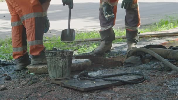 Krivoy Rog, Ucrânia - JUNHO 08. 2021: uma equipe de reparo remove um bloqueio no esgoto que causou inundações de várias ruas Prores422, bmpcc4k slowmo — Vídeo de Stock