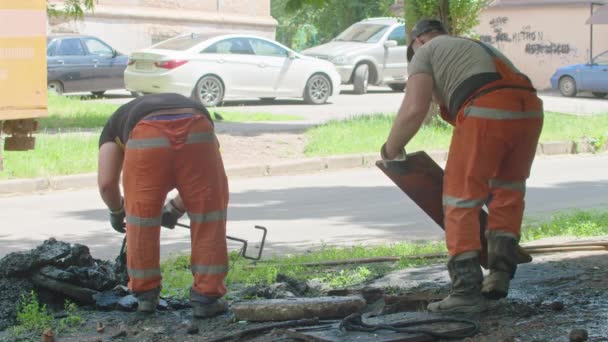 KriwojRog, Ukraine - 08. Juni 2021: Ein Reparaturteam beseitigt eine Verstopfung im Abwasserkanal, die zu Überschwemmungen mehrerer Straßen geführt hat. — Stockvideo