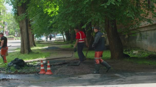 Krivoy Rog, Ucrania - JUNIO 08. 2021: un equipo de reparación elimina un bloqueo en la alcantarilla que ha causado inundaciones en varias calles Prores422, bmpc4k slow — Vídeos de Stock