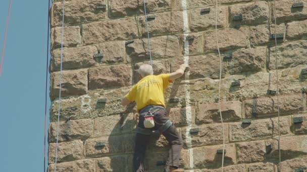 Kryvyi Rih, Ukraina - 05.23.2021 en bergsklättrare klättrar ett stenställ, en pelare av en gammal bro, en gammal klättrare hockey ProRes 422, bmpcc4k — Stockvideo