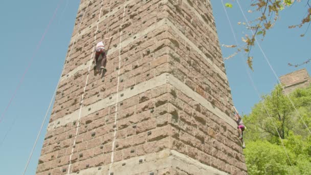 Kryvyi Rih, Oekraïne - 05.23.2021 een rotsklimmer beklimt een stenen standaard, een zuil van een oude brug, een oude klimmers hockey ProRes 422, bmpcc4k — Stockvideo