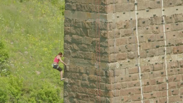 Kryvyi Rih, Ukrajina - 05.23.2021 horolezec šplhá po kamenném podstavci, sloup starého mostu, starý horolezec hokejové ProRes 422, bmpcc4k — Stock video