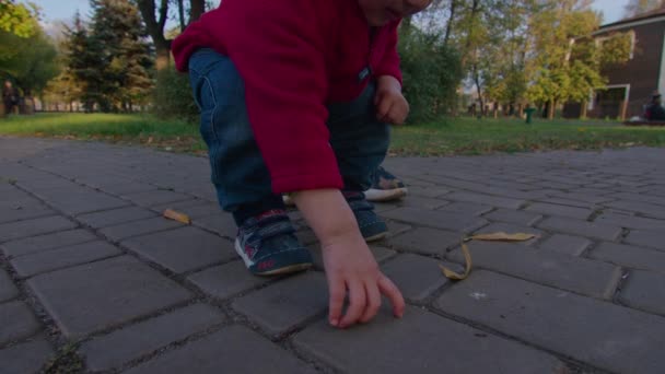 Mère est sortie dans la rue avec un petit enfant, joue avec lui dans ses bras, l'enfant fait les premiers pas et apprend à marcher, une famille heureuse, l'enfant apprend le monde, Prores 422, bmpcc4k. — Video