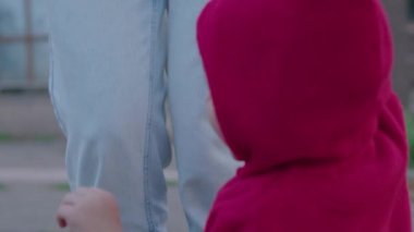 Anne küçük bir çocukla sokağa çıktı, kollarında onunla oynadı, çocuk ilk adımı attı ve yürümeyi öğrendi, mutlu bir aile, çocuk dünyayı öğrendi, Prores 422, bmpc4k.