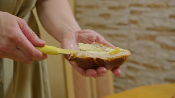 Filmagens comerciais, uma jovem corta pão com uma faca, espalha um sanduíche com manteiga e derrama mel, dança e come uma sanduíche, sorri para a câmera. Prores422 — Vídeo de Stock
