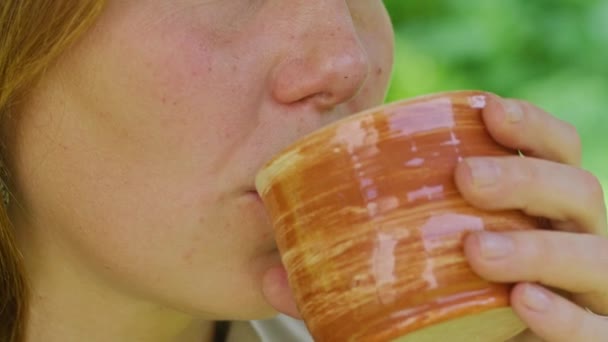 夏の少女は熱いお茶を飲むスイングに座って庭でお茶は最高の熱に役立ちますProres422 — ストック動画