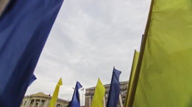 Ukrayna ulusal bayrağı bulutlu gökyüzüne karşı rüzgarda dalgalanıyor. Bayrak direğindeki Ukrayna bayrağı rüzgarda dalgalanıyor.