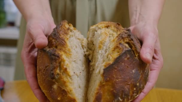 Werbefotos, ein Mädchen backt Brot, sie schneidet es mit einem Messer, bricht es mit den Händen, erschnüffelt es, es riecht wunderbar. Verbindung mit Kindheit und Elternhaus. Prospekt422. — Stockvideo