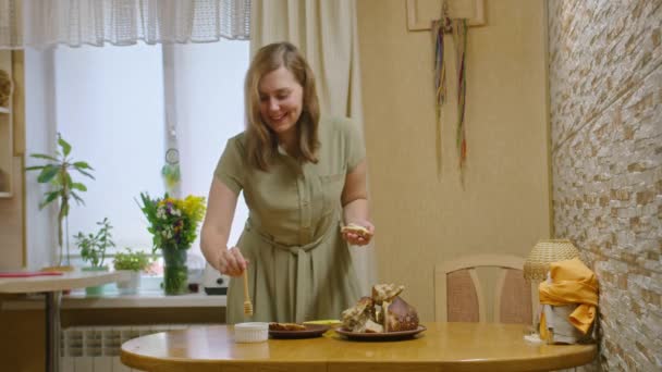 Metraje comercial, una joven corta pan con un cuchillo, extiende un sándwich con mantequilla y vierte miel, baila y se come un sándwich, sonríe a la cámara. Prores422 — Vídeo de stock