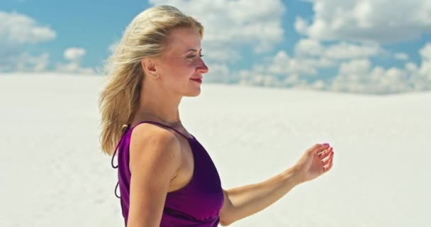 Filmreife Zeitlupe einer Frau, die auf einer Sanddüne geht. Barfüßige Reisende in einem Kleid, das im Wind auf der welligen Oberfläche der Sandwüste schwingt, mit einer Wolke im Hintergrund. 4K Scenic — Stockvideo