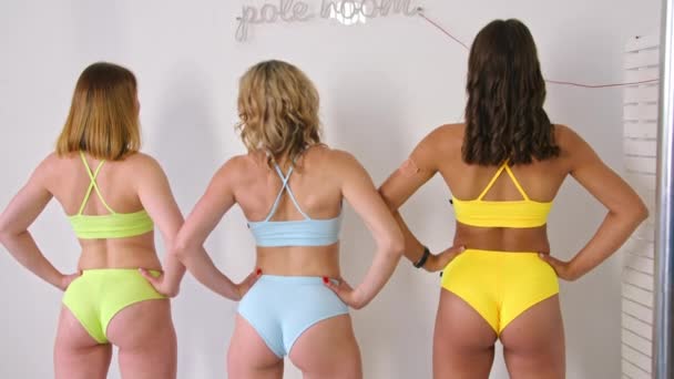 Girls pose in a photo studio in swimsuits, advertising them for sale. Prores422. — Stock Video