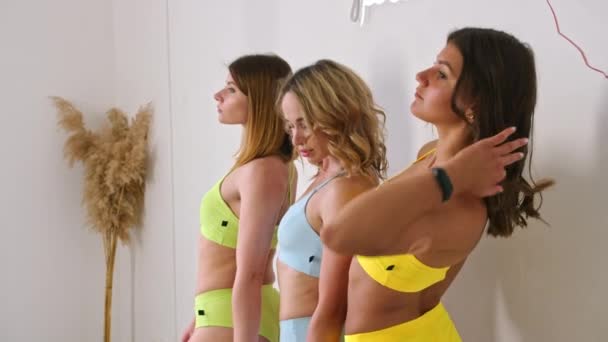 Mädchen posieren in Badeanzügen in einem Fotostudio und werben für den Verkauf. Prospekt422. — Stockvideo