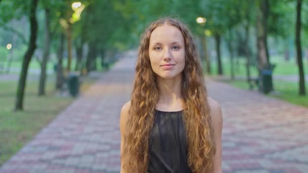 Tournage de publicité, une jeune fille dans le parc sourit, un beau sourire. — Video