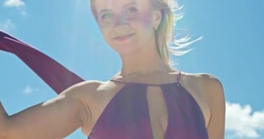 Kum tepeciğinde yürüyen bir kadının sinematik yavaş çekimi. Çıplak ayaklı kadın gezgin rüzgarda sallanan bir elbiseyle kumlu çölün dalgalı yüzeyinde arka planda bir bulutla. 4K Manzarası