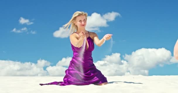 Cinematic slow motion of a woman walking on a sand dune. Barefoot woman traveler in a dress swinging in the wind on the undulating surface of the sandy desert with a cloud in the background. 4K Scenic — Stock Video