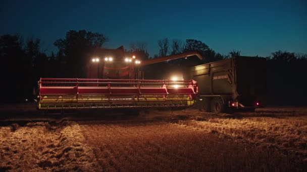 Oogstmachine 's nachts in het veld oogst tarwe, zeldzame beelden, doet denken aan de stalen hand van de Heer. — Stockvideo