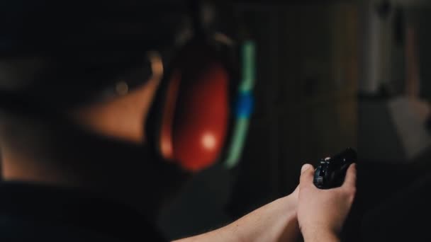 Стрелок полиции тренируется стрелять против часов с инструктором из пистолета, в специальном стрельбище. — стоковое видео