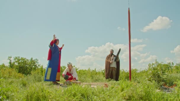 The shaman, the priestess and the helper perform the rite of sacrifice, invoking the gods, precipitation and a good harvest. — Stock Video