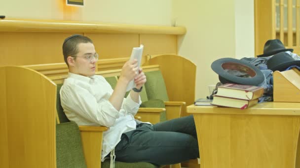 Kryvyi Rih, Ukraine - 08.03.2021 a Jewish boy is reading a book in the synagogue, he is doing his homework. — Wideo stockowe