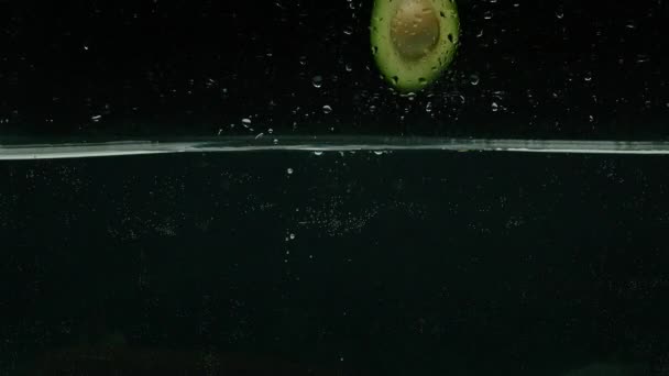 Avokado och tomat störtar i vatten, slow motion, prores 422, bmpcc4k — Stockvideo