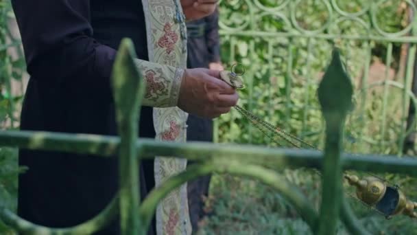 Kriwoj Rog, Uktaine - 08.10.2021 ein orthodoxer Priester und sein Assistent lesen ein Gebet auf dem Friedhof und führen eine Zeremonie durch — Stockvideo