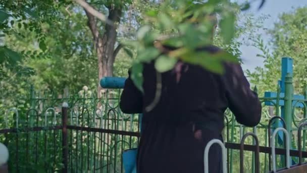 Krivoy Rog, Uktaine - 08.10.2021 een orthodoxe priester en zijn assistent lezen een gebed op het kerkhof en voeren een ceremonie uit — Stockvideo
