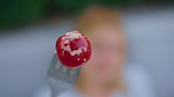 Młoda kobieta delektująca się pyszną sałatką z kurczaka, pomidorów i grzanek, jedząc ją widelcem, w pięknym chłodnym miejscu w gorące lato. — Wideo stockowe