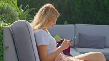 Genç bir kadın telefonda konuşmaktan hoşlanır, biriyle mesajlaşmaktan, harika bir yerde, beyaz bir tişörtle oturmaktan.