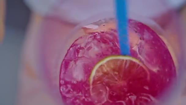 Hand einer jungen Frau, die mit einem Strohhalm einen Cocktail in einem Glas rührt, Nahaufnahme — Stockvideo