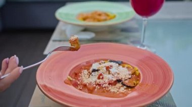 Genç bir kadın somon ve patlıcanla makarna yemekten hoşlanır, sıcak yaz mevsiminde güzel serin bir yerde çatalla yemekten..