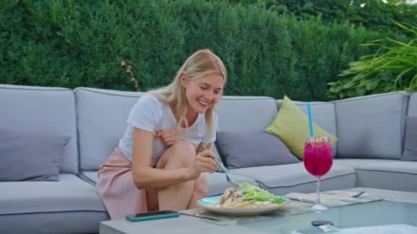 Genç bir kadın lezzetli bir tavuk, domates ve kızarmış ekmek salatasının tadını çıkarıyor. Sıcak yaz mevsiminde çatalla yiyor.. — Stok video