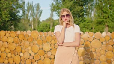 Genç bir kadın güzel bir yerde dinlenmekten zevk alır, kameraya yüzünü buruşturur, eğlenir, şımartır..