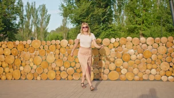 Uma jovem mulher gosta de relaxar em um lugar bonito, sorrindo para a câmera, se divertindo, se entregando. — Vídeo de Stock