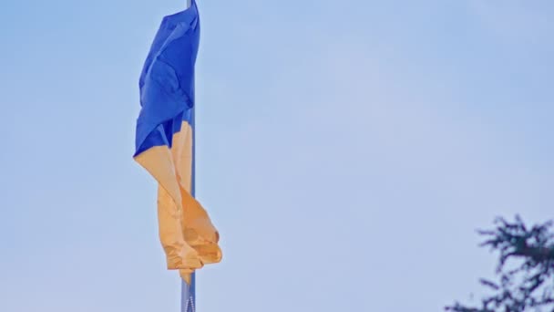 Vlajka Ukrajiny, hedvábná vlajka vlající na pozadí zapadajícího modrého nebe na velkém stožáru. — Stock video