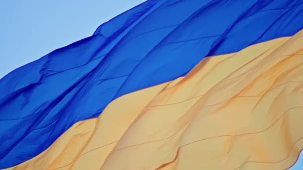 Vlajka Ukrajiny, hedvábná vlajka vlající na pozadí zapadajícího modrého nebe na velkém stožáru. — Stock video
