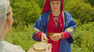 Yeniden yapılanma. Sarmatya kurban ayininde, rahibe ve yardımcısı o zamanlar insanların yaptığı şeyleri yaparak tanrıları çağırır ve iyi bir hasat isterler..