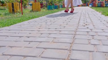 Beyaz elbiseli genç, mutlu kadın sokakta yürüyor, poster, bacaklar, yakın plan.