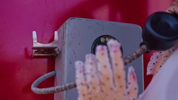 Hermosa mujer joven felizmente hablando por teléfono en una cabina telefónica roja en estilo Inglés. chica en un vestido blanco y gafas. Pin para arriba. marca un número de teléfono, primer plano. — Vídeo de stock