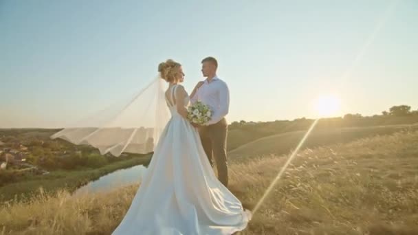 O casal de casamentos está se divertindo ao pôr do sol nas montanhas junto ao rio. — Vídeo de Stock