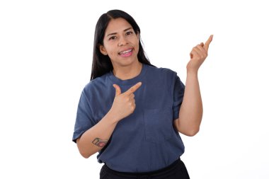 Mavi tişörtlü mutlu kadın, şaşırmış, beyaz arkaplan, sağ tarafı işaret ediyor.