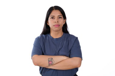 Beyaz arka planda mavi gömlekli bir kadın kollarını kavuşturmuş ciddi bir jest, memnuniyet ifadesi ya da onaylama ile.