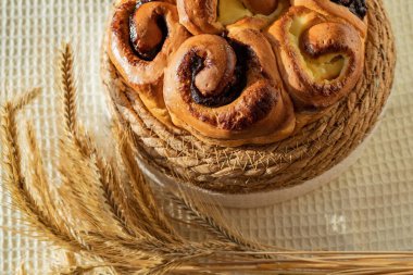 Altın kabuklu ve kuru üzümlü taze pişmiş tatlı çörek. Fırın reklamcılığı ve menü tasarımı için mükemmel bir resim.