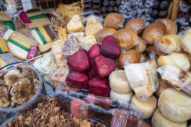 Geleneksel Ukrayna çiftlik pazarında çeşitli renkli peynirler, tütsülenmiş etler ve kurutulmuş mantarlar sergileniyor. Karpatya bölgesinden doğal ev yapımı organik gıda..