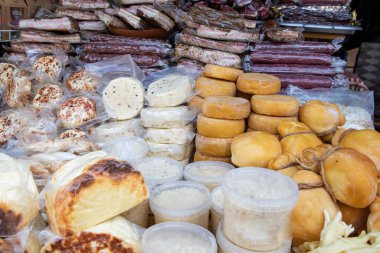 Assorted smoked bacon and colorful cheeses displayed on traditional Ukrainian farm market. Natural homemade organic food products from local farmers.
