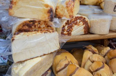 Assorted traditional smoked and fresh cheeses displayed on counter at local market in the Carpathians, Ukraine. Natural organic dairy products from village farm.