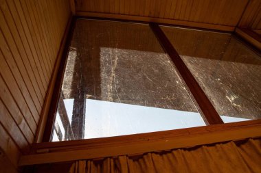 Dusty glass ceiling window in wooden interior house illuminated by sunlight concept of home cleaning maintenance and hygiene